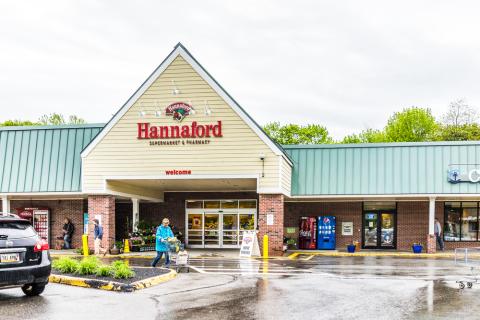 a group of people standing in a parking lot in front of a building